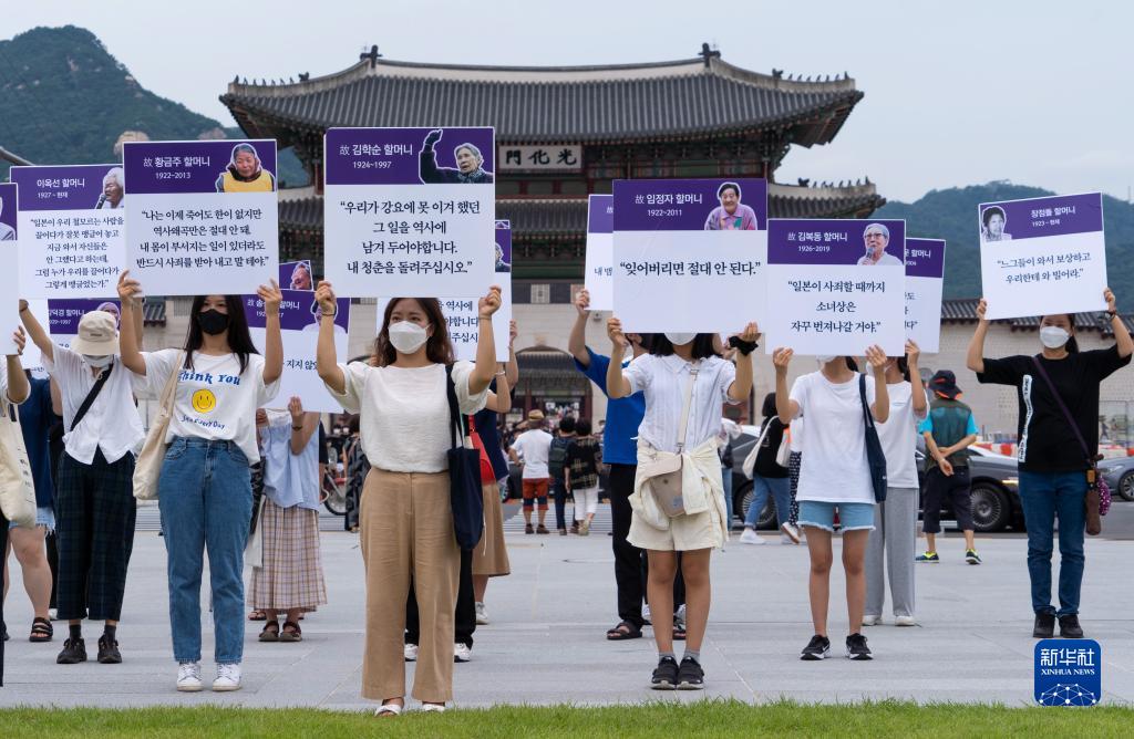 8月14日、韓国ソウルの光化門広場で、日本軍「慰安婦」被害者の写真と証言を掲げ、抗議集会に参加する市民（撮影・李相浩)。