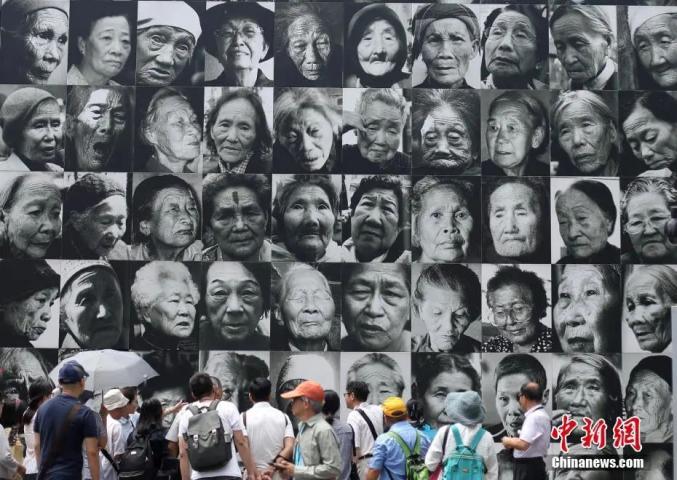 資料写真：2018年8月14日、「慰安婦」記念日に南京利済巷慰安所旧址陳列館を見学し、「無言の訴え」を聞く人々（撮影・泱波）。