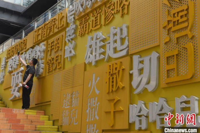 「重慶方言」の壁の前で自撮りする男性（撮影・周毅）
