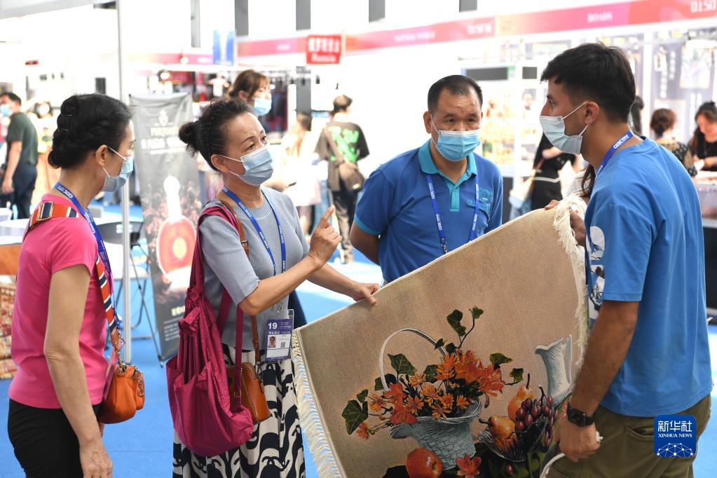 中国・ASEAN 博覧会の「一帯一路（the Belt and Road）」国際展示エリアで、ベラルーシの絨毯を選ぶ来場者（9月18日撮影・周華）。