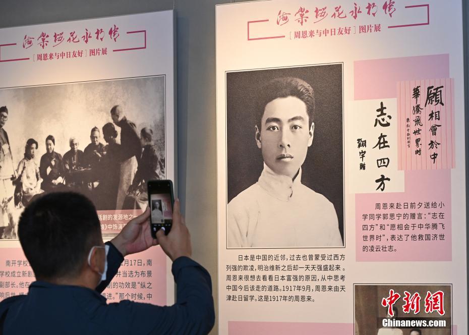 北京会場で、展示された若き日の周恩来の写真を撮影する来場者（撮影・侯宇）。