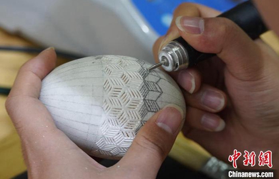 彫刻刀を器用に使って卵の殻に装飾を施す甘粛省の大学生