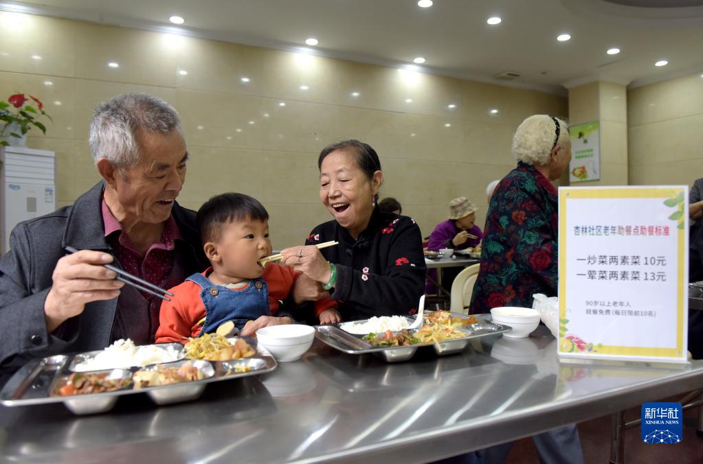安徽省合肥市蜀山区石油賓館高齢者支援食堂で孫と一緒に食事をする蒋明珠さん（写真左）と朱文秀さん（写真左から3番目、10月8日撮影・郭晨）。