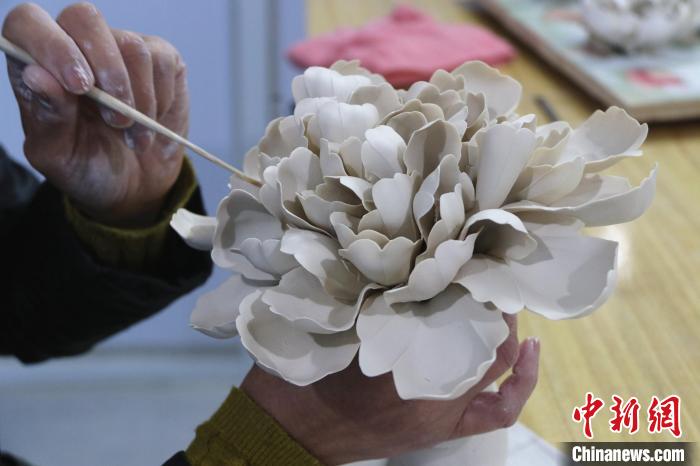 山東省菏沢市牡丹区の作業場で牡丹の花びらの形を整える作業（10月11日撮影・郜玉華）。
