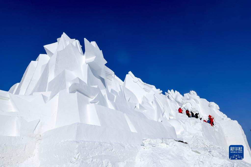 第35回太陽島雪像博の会場で、大型雪像の制作に取り組む彫刻家（12月18日撮影・王松）。