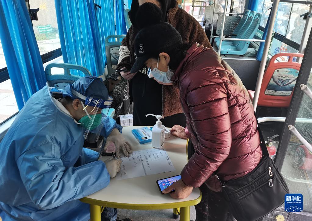 江寧区麒麟街道（エリア）の華匯康城団地で、発熱外来移動診療車の中で医療サービスを提供する医師（12月20日撮影）。