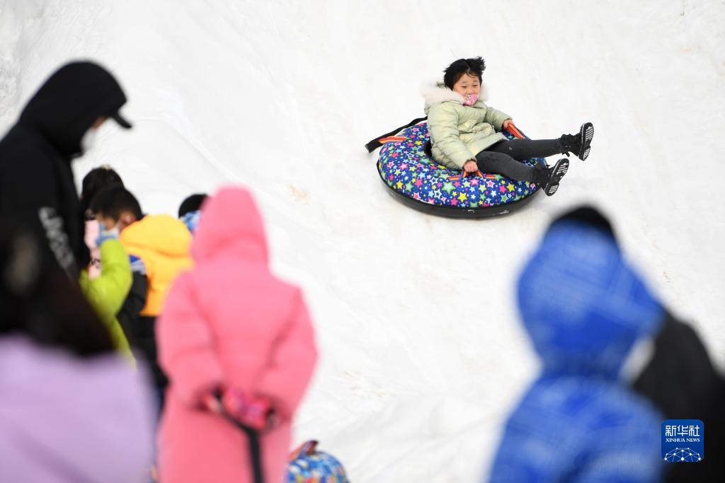 甘粛省蘭州市にある北山林場で開幕した氷雪カーニバルで、雪上レクリエーションを体験する観光客（12月25日撮影・陳斌）。