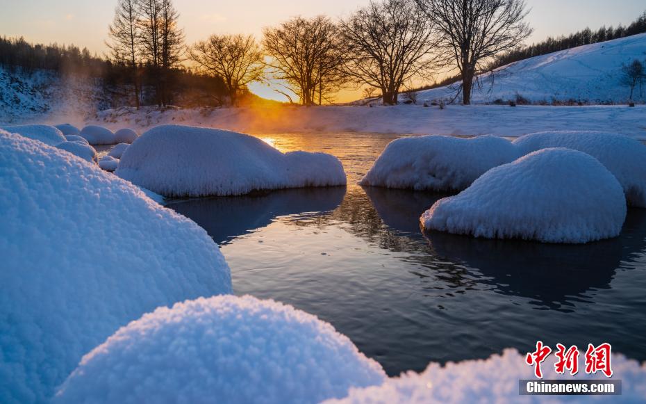 「凍らない川」に浮かぶ、真っ白で餅のようにこんもりとした雪の塊（撮影・李明）。
