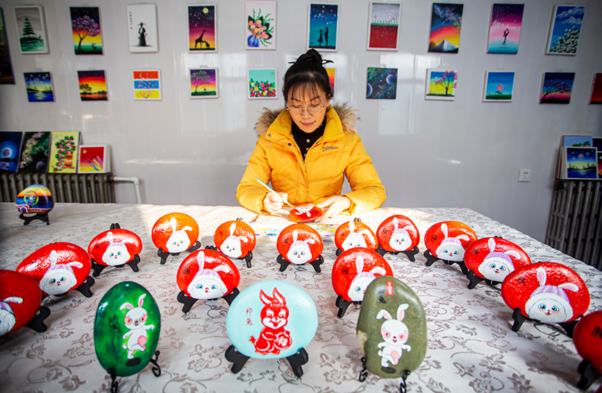 河北省邯鄲市復興区戸村鎮林村で、「百兎迎春」シリーズのストーンアートを制作する宿静さん（撮影・聶長青）。