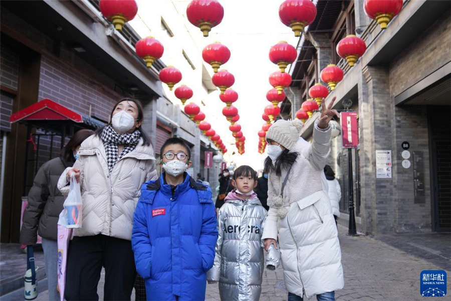 1月28日、北京市東城区鮮魚口街でツアー客に解説するガイドの何静さん（写真一番右、撮影・鞠煥宗）。