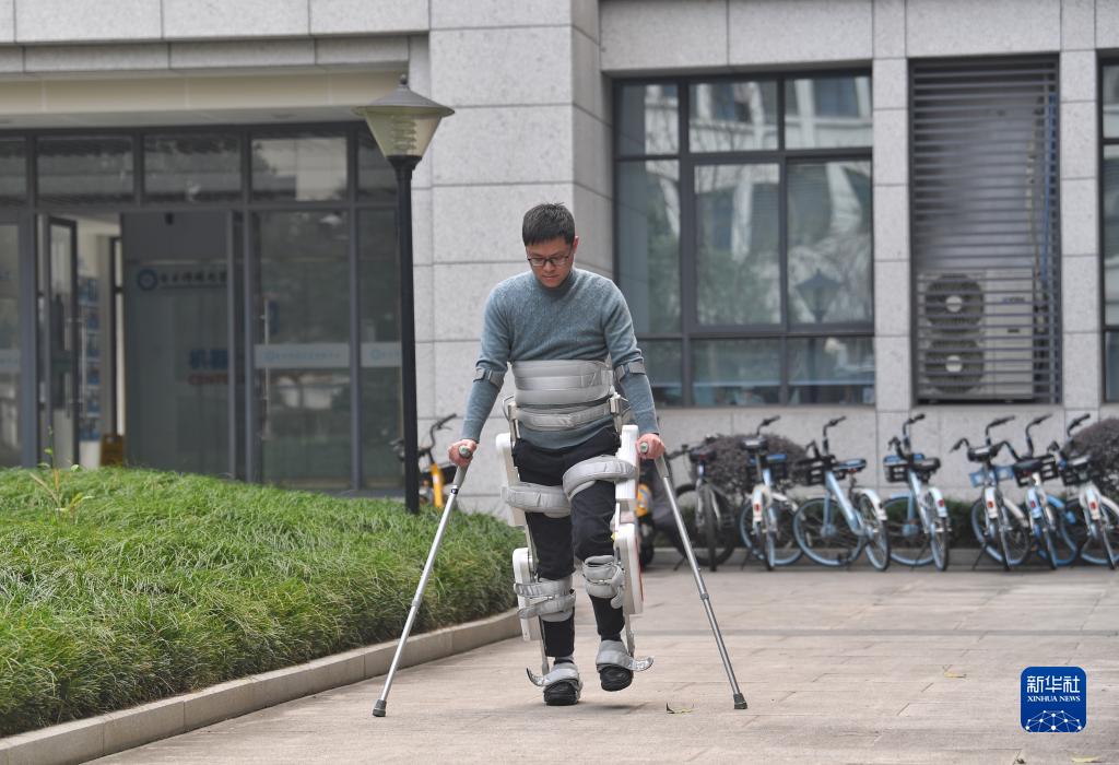 外骨格ロボットの補助を受け歩行訓練を行う対麻痺患者（3月6日撮影・劉坤）。