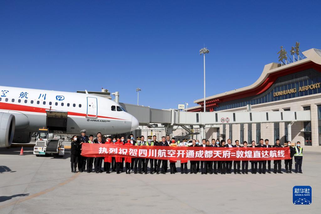 四川航空が運航する成都－敦煌往復直行路線が就航し、甘粛省敦煌市の莫高国際空港で、集合写真を撮影する就航第一便の乗務員と空港職員（3月26日撮影・張暁亮）。