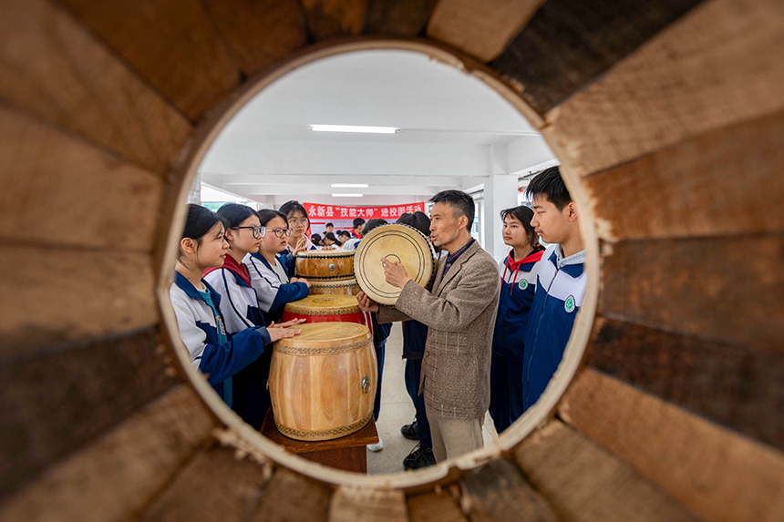 江西省吉安市永新県でこのほど実施された、「技の達人」を学校に招く活動。子供たちに太鼓の製造方法を教える、太鼓作りの達人（撮影・王恵民）。