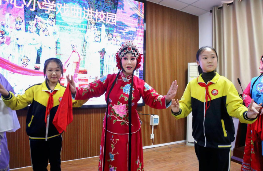 児童に伝統演劇の動きについて指導する伝統演劇の役者（撮影・王洪勝）。