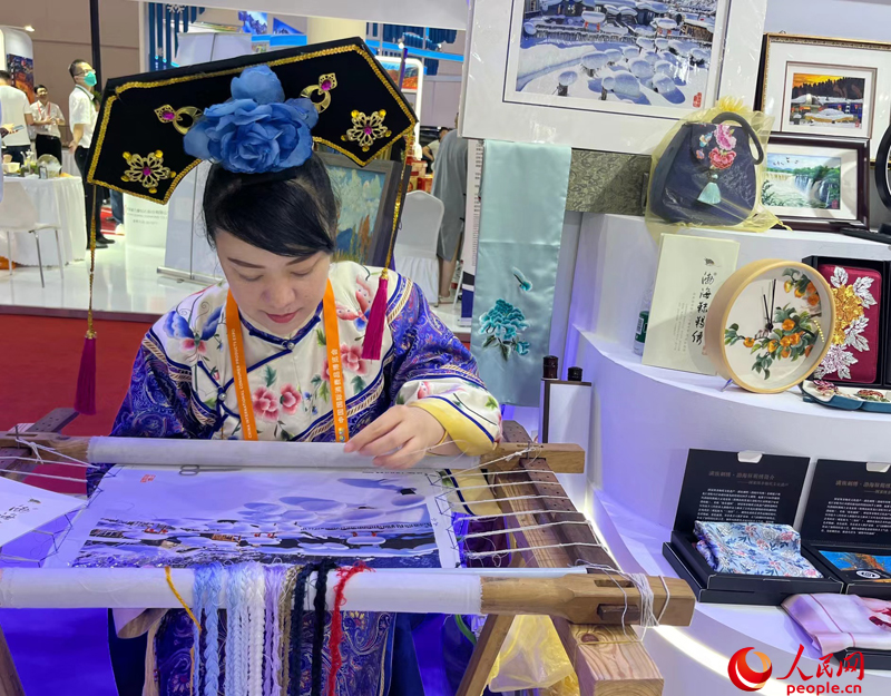 国の無形文化遺産である「渤海靺鞨繍」を披露する出展者（撮影・杜燕飛）。