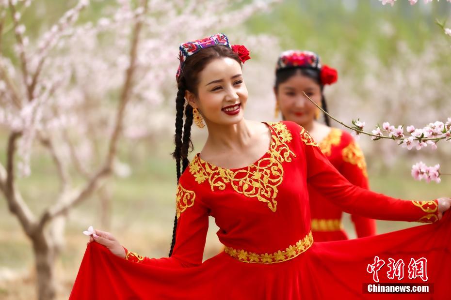 桃の林で遊ぶ新疆の美しい女性たち