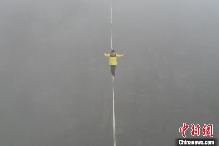 雲の中を歩くように高所を進むスラックラインの達人　湖南省平江