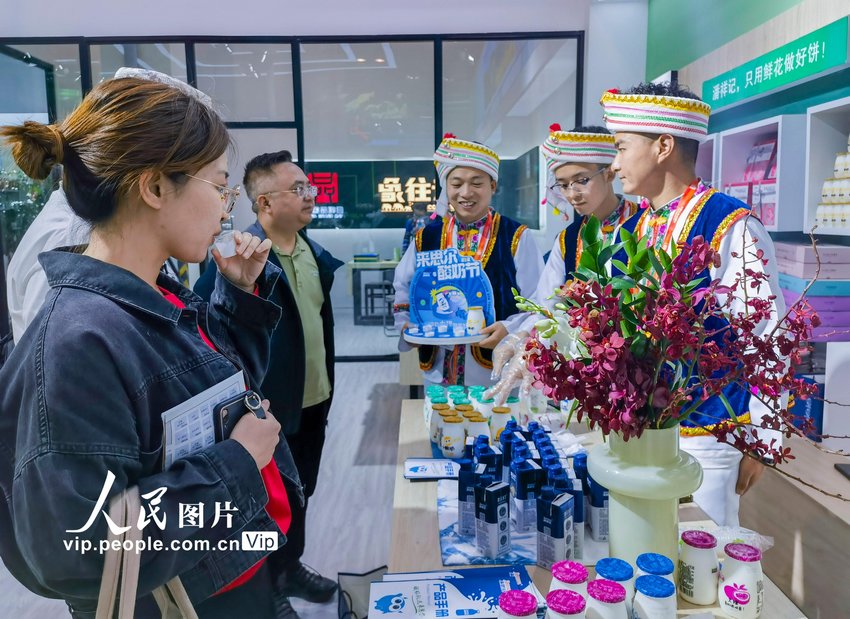 2023年「中国ブランドデー」会場で、雲南省産のヨーグルトを試食する来場者（5月10日撮影・孫志芳/写真著作権は人民図片が所有のため転載禁止）。