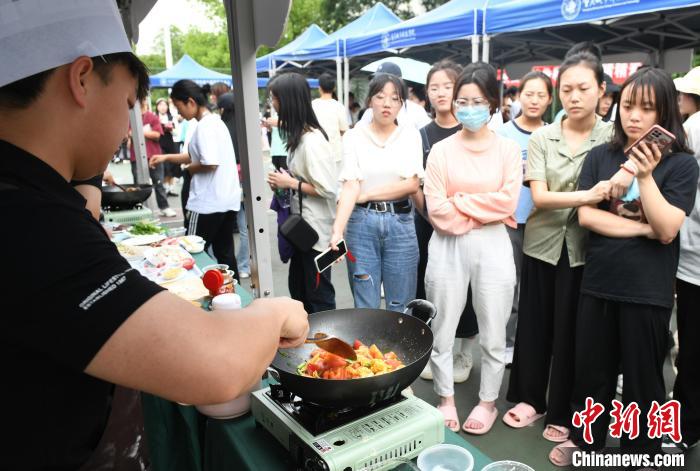 コンテスト会場で料理の腕を披露し、人々の注目を集めた大学生（撮影・周毅）。
