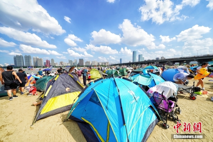 資料写真：哈爾浜（ハルビン）市の松花江のほとりの海水浴場では、市民が砂浜にテントを張っていた。（撮影・孫漢侖）