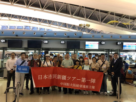 大阪の関西国際空港で出発前に記念写真を撮影する日本市民新疆ツアー第一陣の参加者と中国人スタッフ。画像は在大阪中国総領事館が提供。