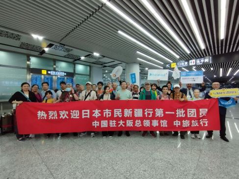 烏魯木斉に到着した日本市民新疆ツアー第一陣の参加者と中国人スタッフ。画像は在大阪中国総領事館が提供。