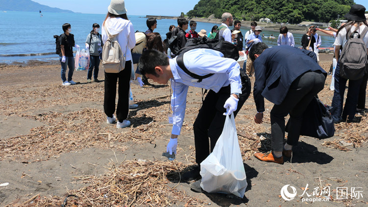 海岸清掃を体験する学生たち（撮影・許可）。