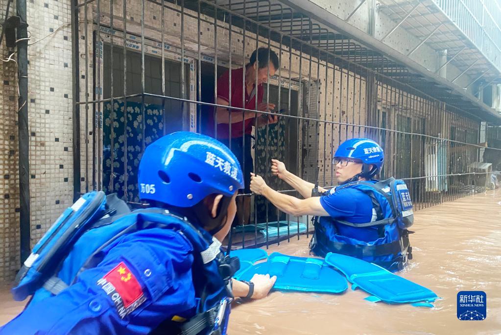 重慶市万州区五橋街道（エリア）で、立ち往生した市民を安全な場所に移送する藍天救援隊の隊員（7月4日撮影・馮涛）。