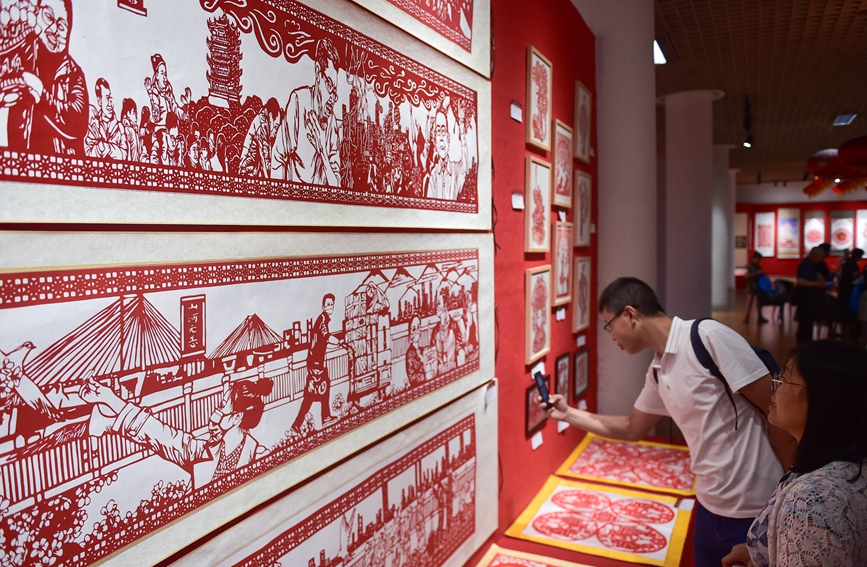 河南省洛陽市で開催された「第1回切り絵芸術伝承展」で、切り絵作品を鑑賞する市民（撮影・黄政偉）。
