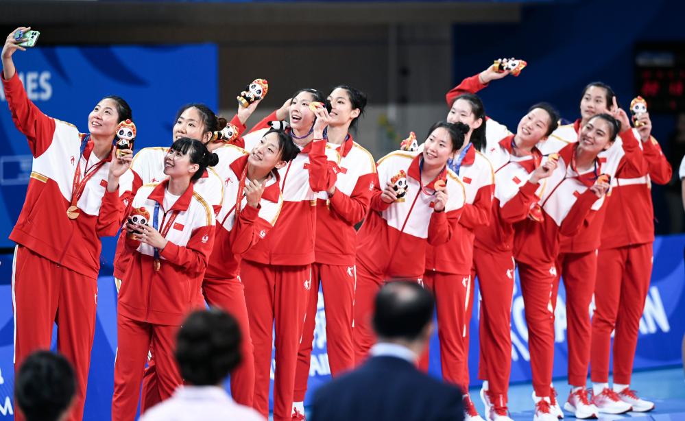 今月6日、表彰式においてスマホで記念写真を撮影する優勝した中国女子バレーボール代表チームのメンバー。撮影・曹禕銘