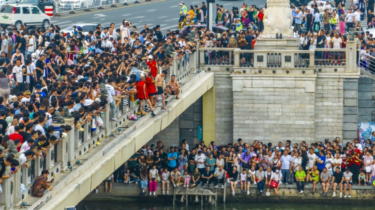 2023年9月3日、天津市獅子林橋の飛び込みスポットに集まった大勢の市民や観光客。秩序を維持し、赤いベスト姿の安全確保ボランティアスタッフは地元の飛び込み愛好者。
