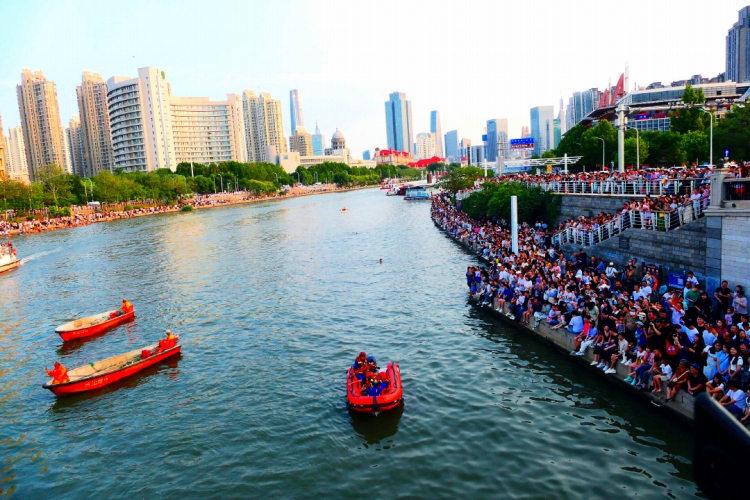 2023年9月2日、天津市の海河にかかる獅子林橋の近くで、岸辺に集まった大勢の観光客。水上では救援隊員がいつでも救助できるよう待機。（写真提供は視覚中国）