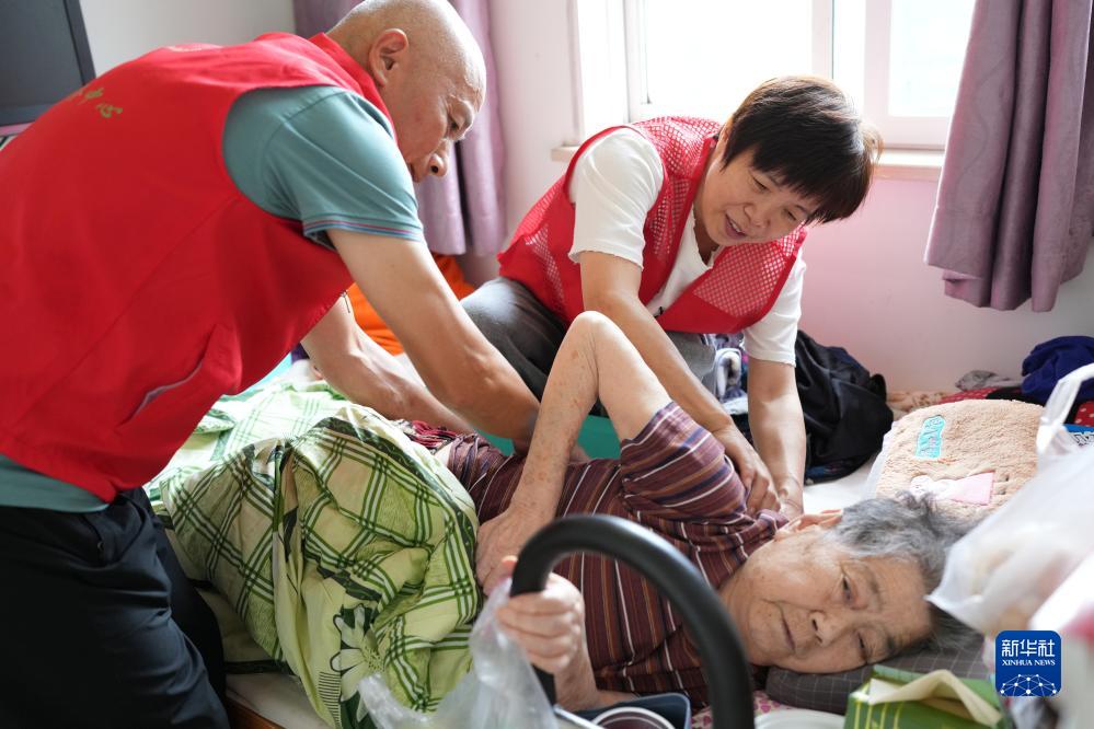 寝たきり高齢者の自宅で訪問サービスをおこなうボランティア（9月13日撮影・翁忻暘）。