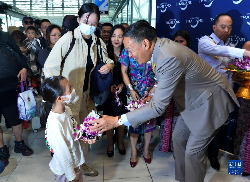 9月25日、バンコクのスワンナプーム国際空港で、中国人観光客を出迎えるタイのセター・タウィーシン首相（写真前列右）。