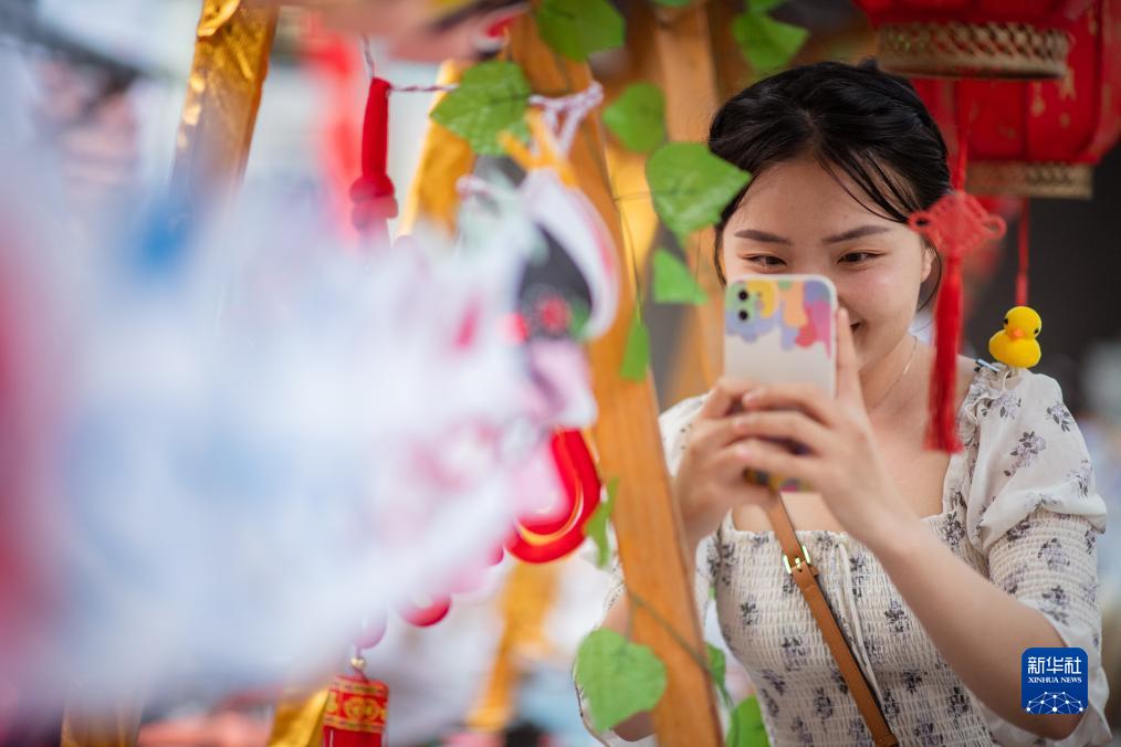 9月29日、湖北省武漢市武昌区の無形文化財「技・憶」節イベント会場で京劇の隈取を撮影する観光客。