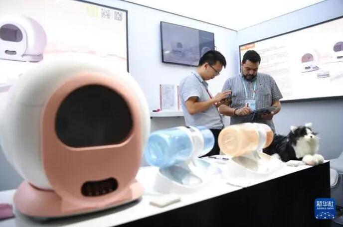 15日、スマート猫用トイレ製品の展示ブースで情報を得る外国人バイヤー。撮影・鄧華