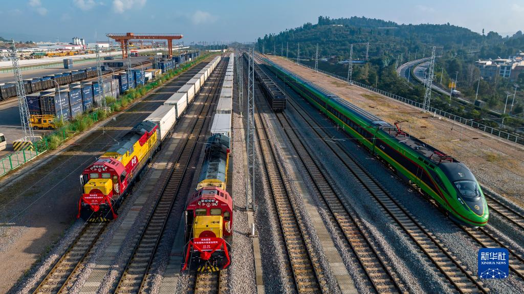 10月16日、雲南省玉渓市研和駅で、中国ラオス鉄道と中国ベトナム鉄道の国際コールドチェーン貨物列車とすれ違う中国ラオス鉄道の国際旅客列車D887「復興号」（写真右、ドローンによる撮影・陳暢）。
