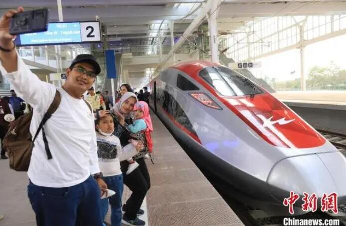 高速列車をバックに自撮りで記念撮影をするインドネシアの4人家族。（撮影・李志全）