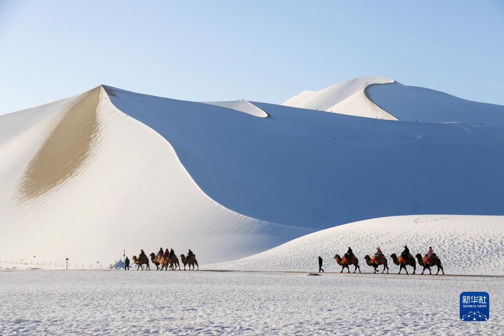 鳴沙山月牙泉景勝地で雪景色をラクダに乗りながら眺める観光客（11月15日撮影・張暁亮）。