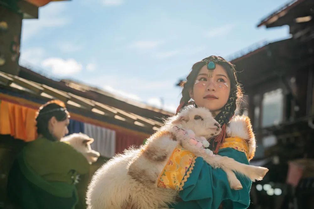独克宗古城で小羊を抱いて記念写真を撮影する女性。