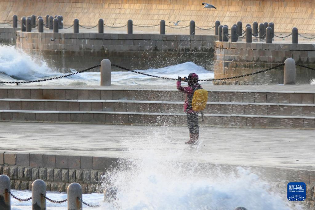 山東省煙台市の海辺で、波の写真を撮影する市民（12月10日撮影・唐克）。