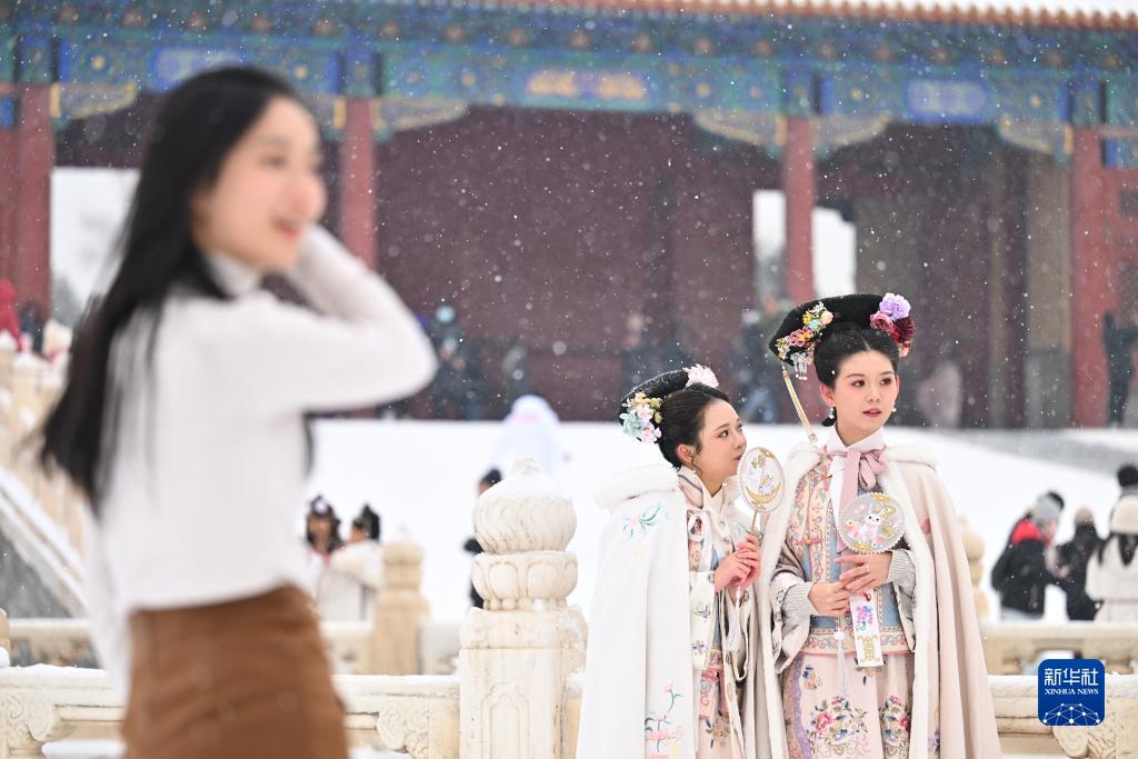雪の中、故宮を観光する人々（12月13日撮影・李鑫）。