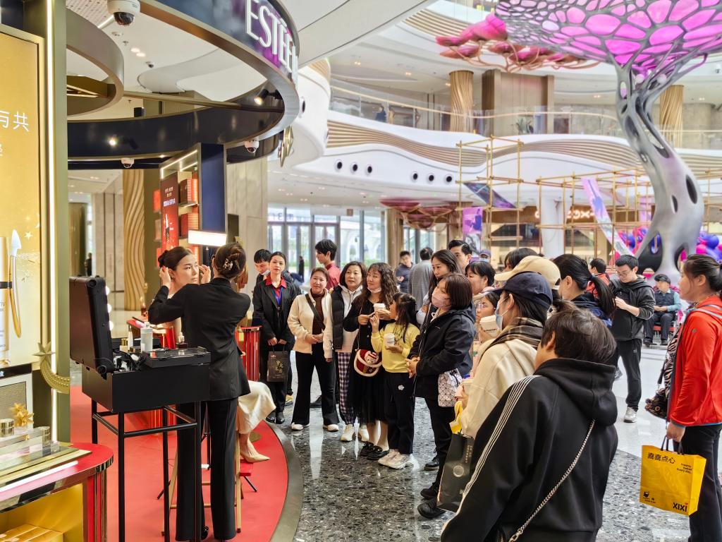 2023年12月24日、海口国際免税城のあるショップで店員が商品の宣伝を行う様子。撮影・呉茂輝