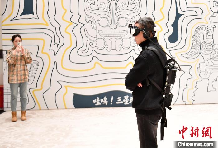 VRゴーグルとバックパックを装着して没入型VR展を体験する来場者（1月9日撮影・韓氷）。