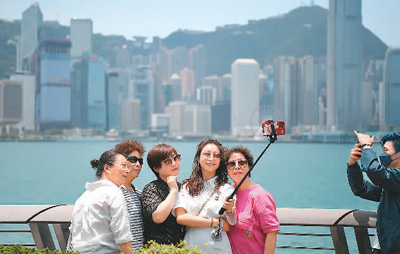 香港特区のアベニュー・オブ・スターズで写真を撮影する観光客（撮影・陳鐸）。