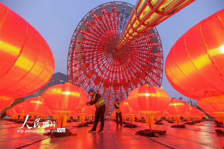 上海浦東新区の「東方の光」大型景観オブジェの下を飾る赤い提灯の最終点検を行う職員（1月31日撮影・王初/写真著作権は人民図片が所有のため転載禁止）。
