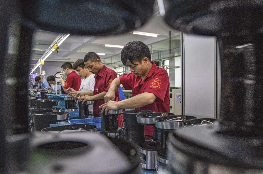 広東省仏山市の電器メーカーの工場でコーヒーメーカーを組み立てる従業員（邱新生/人民図片）