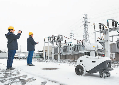 写真：安徽省亳州市の変電所で2日、電力供給設備の点検を行う5Gスマートロボットと運用保守要員。撮影・梁西海