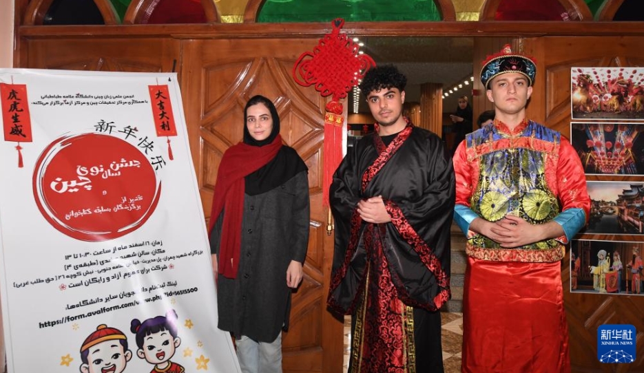 3月6日、イランの首都テヘランにあるアッラーメ・タバータバーイー大学で開かれた中国文化体験イベントで、記念写真を撮影する中国語学科のサラ主任（写真左）と中国の伝統衣装を着た学生たち。
