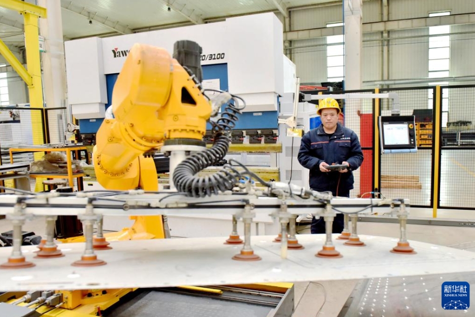 河北省邢台市威県ハイテク区にある電力設備会社で、ロボットアームを操作する作業員（3月11日撮影・王暁）。